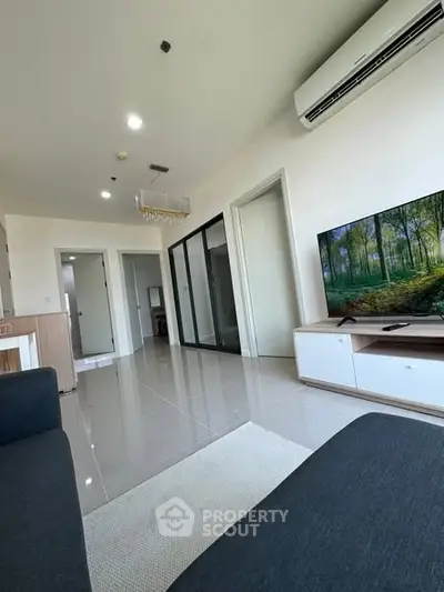 Modern living room with sleek design and large TV, perfect for relaxation.