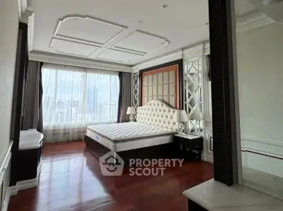 Luxurious bedroom with elegant decor and city view, featuring a plush headboard and large windows.