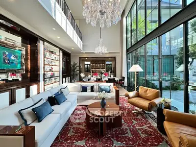 Luxurious living room with high ceilings, elegant chandeliers, and large windows offering a stunning view.