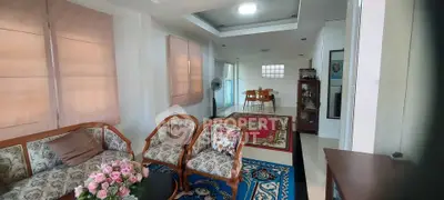 Charming living room with elegant furniture and vibrant rugs, leading to a cozy dining area.