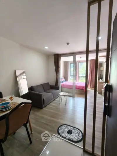 Modern open-plan apartment with cozy living area and bedroom, featuring stylish decor and natural light.
