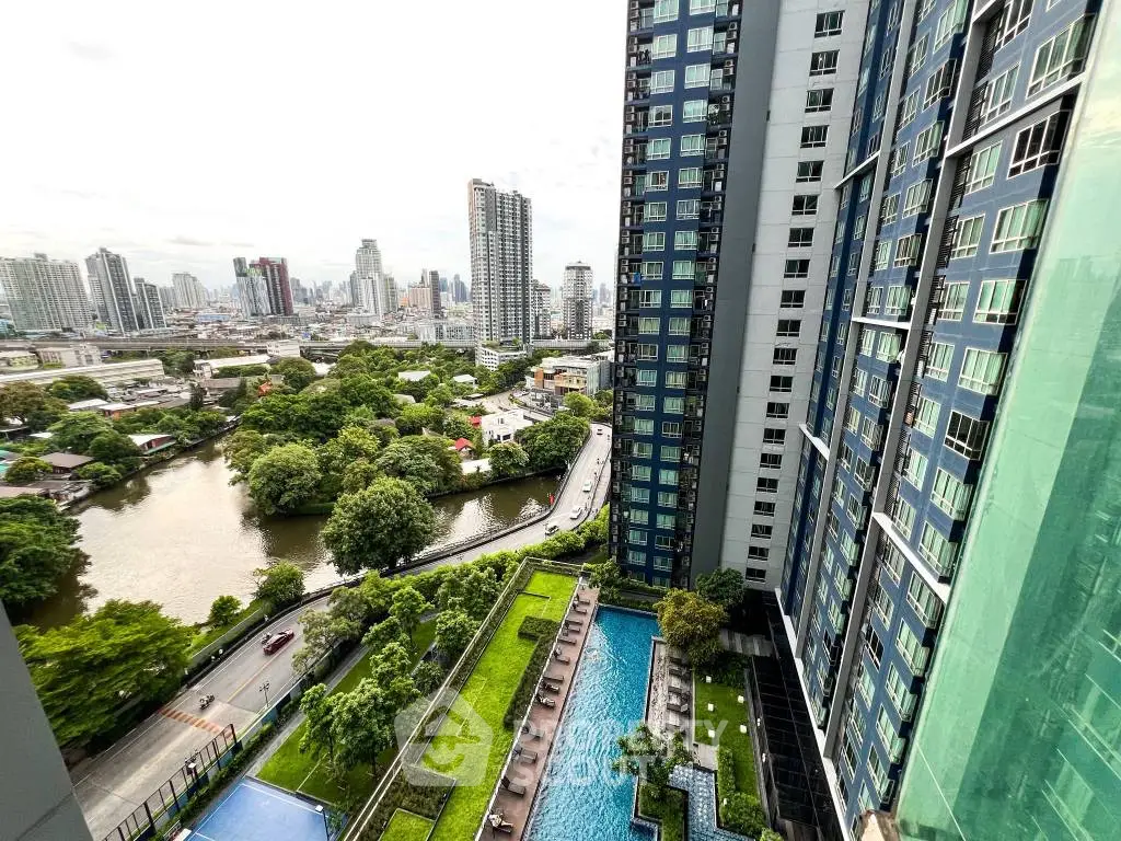 Stunning cityscape view from high-rise apartment with pool and lush greenery.