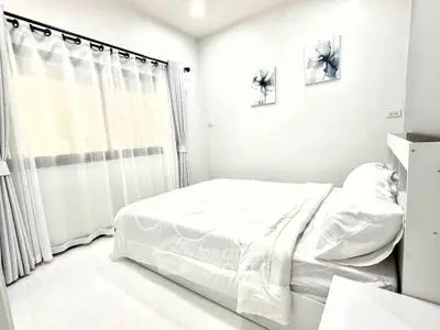 Bright and airy bedroom with modern decor and large window for natural light.