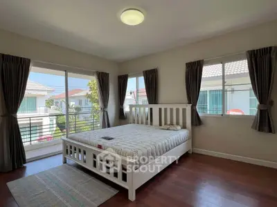 Bright and airy bedroom with large windows and modern decor in a suburban home.