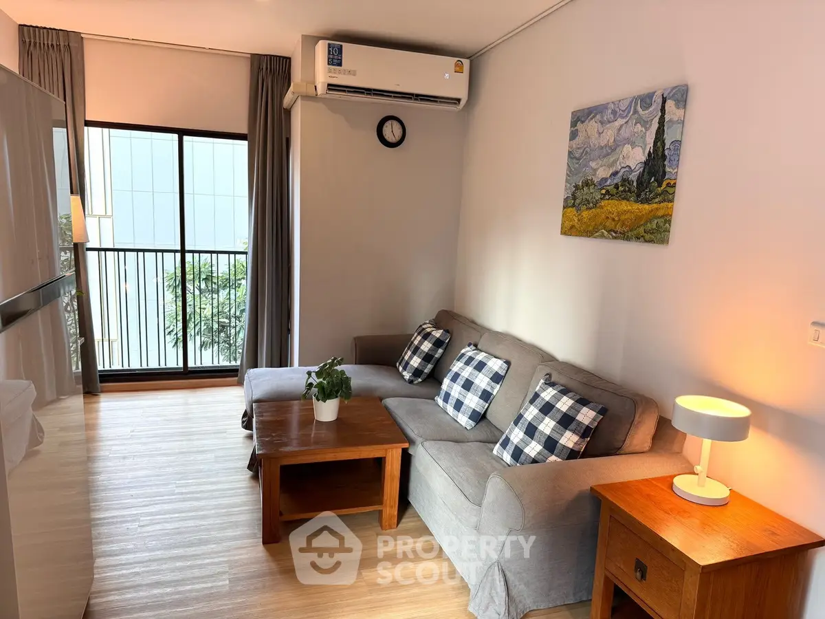 Cozy living room with modern decor and balcony view in a stylish apartment.