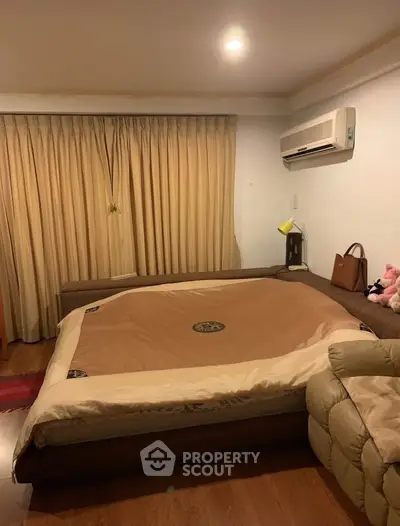 Cozy bedroom with large bed and air conditioning, perfect for restful nights.