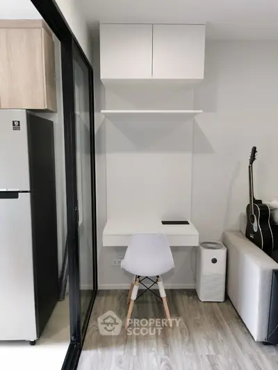 Modern compact study nook with white desk and chair, adjacent to a cozy living area.