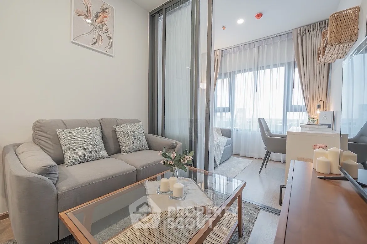 Modern living room with stylish decor and large windows offering natural light.