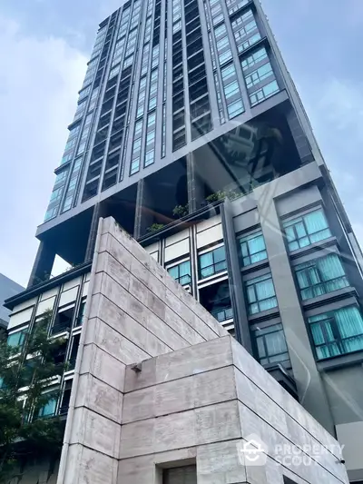 Modern high-rise building with sleek architecture and large windows in urban setting.