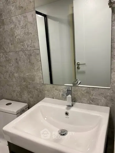Modern bathroom with sleek sink and mirror in contemporary design.