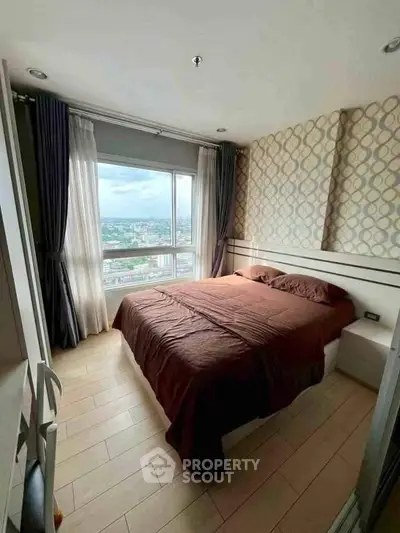 Cozy bedroom with large window offering stunning city views, featuring elegant decor and ample natural light.