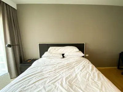 Cozy bedroom with modern decor and natural light, perfect for relaxation and comfort.