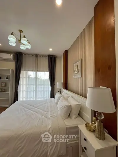Elegant bedroom with modern decor, featuring a cozy bed, stylish lighting, and natural light from large windows.