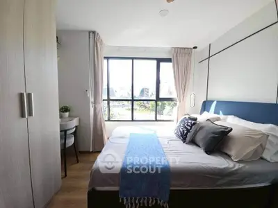 Cozy bedroom with large window and stylish decor in modern apartment