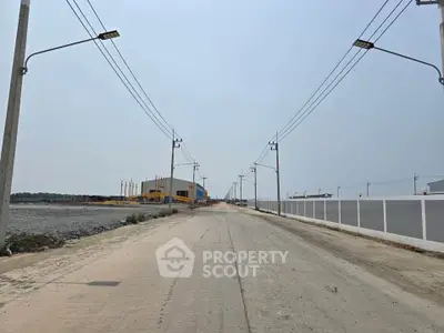 Expansive industrial area with wide road and modern infrastructure, ideal for commercial development.
