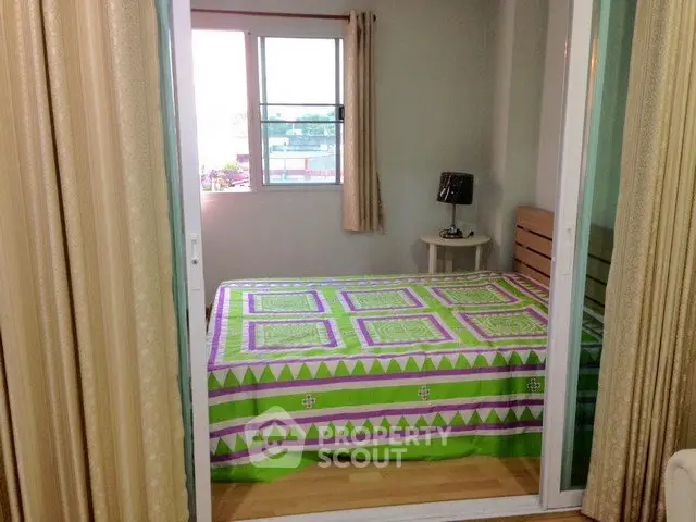 Cozy bedroom with vibrant bedding and natural light from window