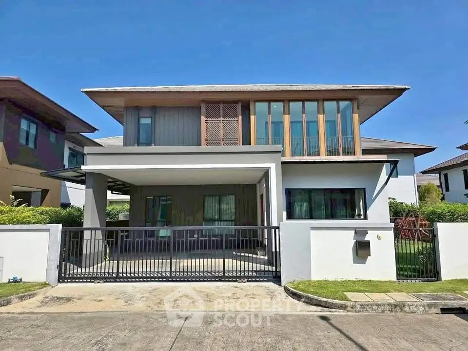 Modern two-story house with sleek design and spacious driveway in a serene neighborhood.