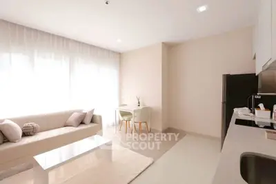 Bright modern living room with cozy sofa and sleek kitchen area