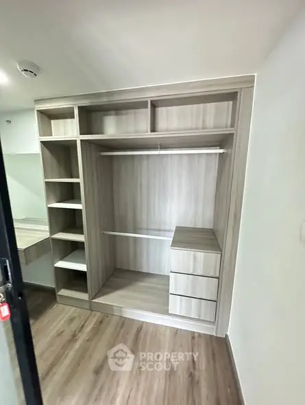 Spacious modern walk-in closet with sleek wooden finish and ample storage space.