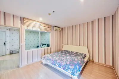 Spacious bedroom with modern decor and floral bedding in a stylish apartment.