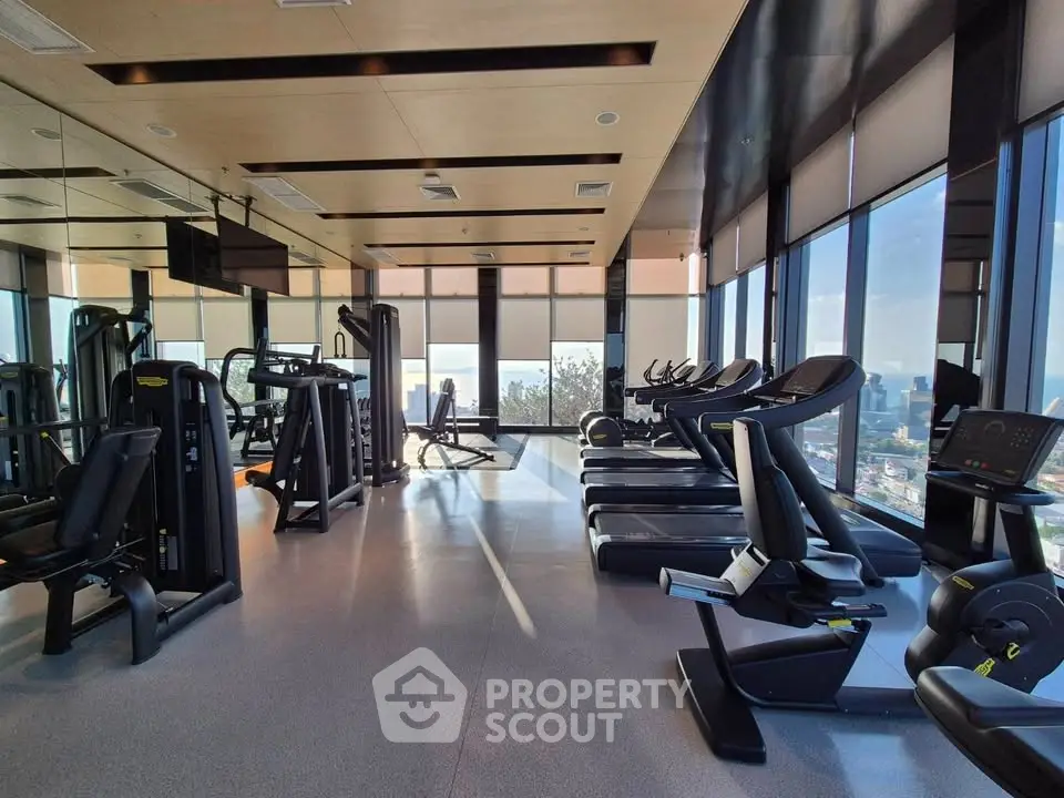 Modern gym with panoramic city views and state-of-the-art fitness equipment.