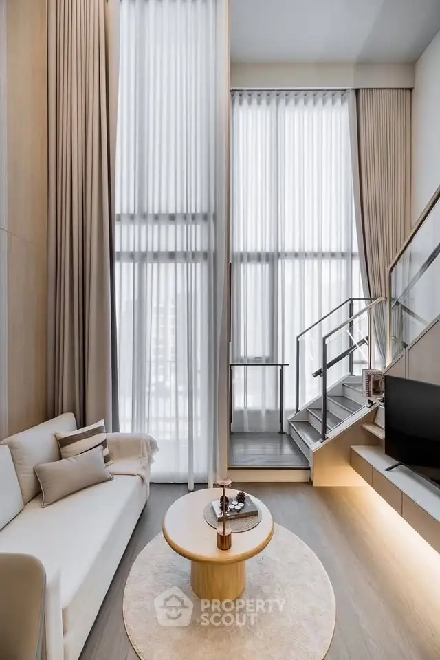 Modern living room with high ceilings and elegant staircase in luxury apartment