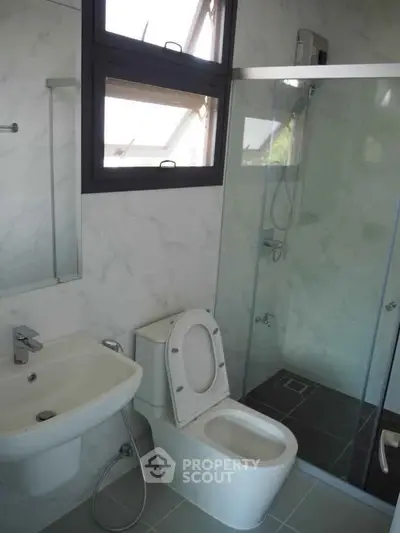 Modern bathroom with glass shower and sleek fixtures in a contemporary home.