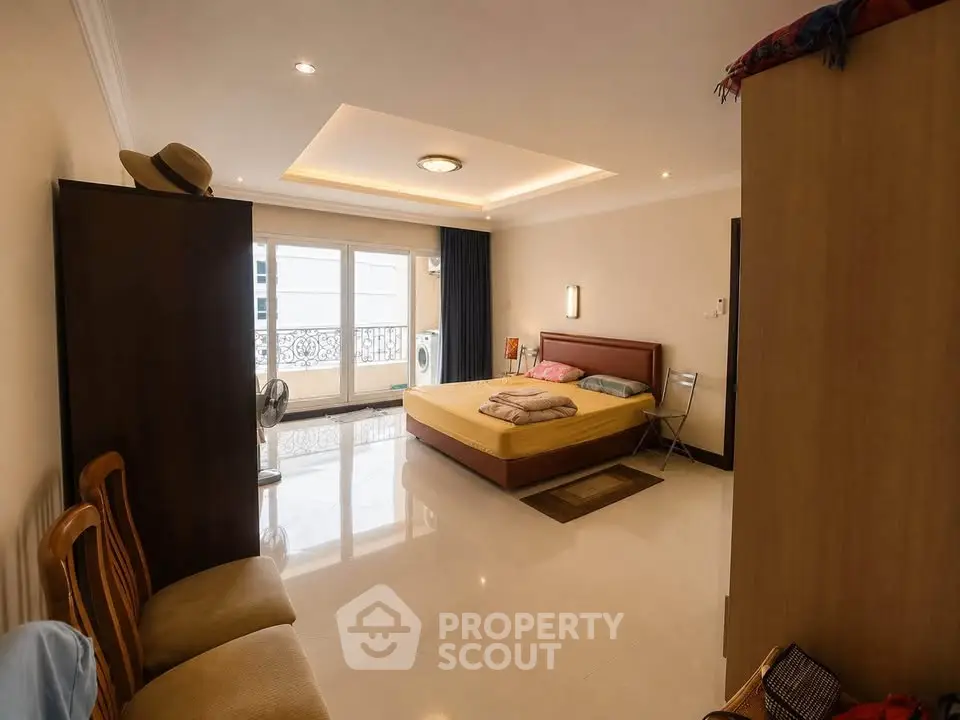 Spacious bedroom with modern decor and large windows offering natural light.