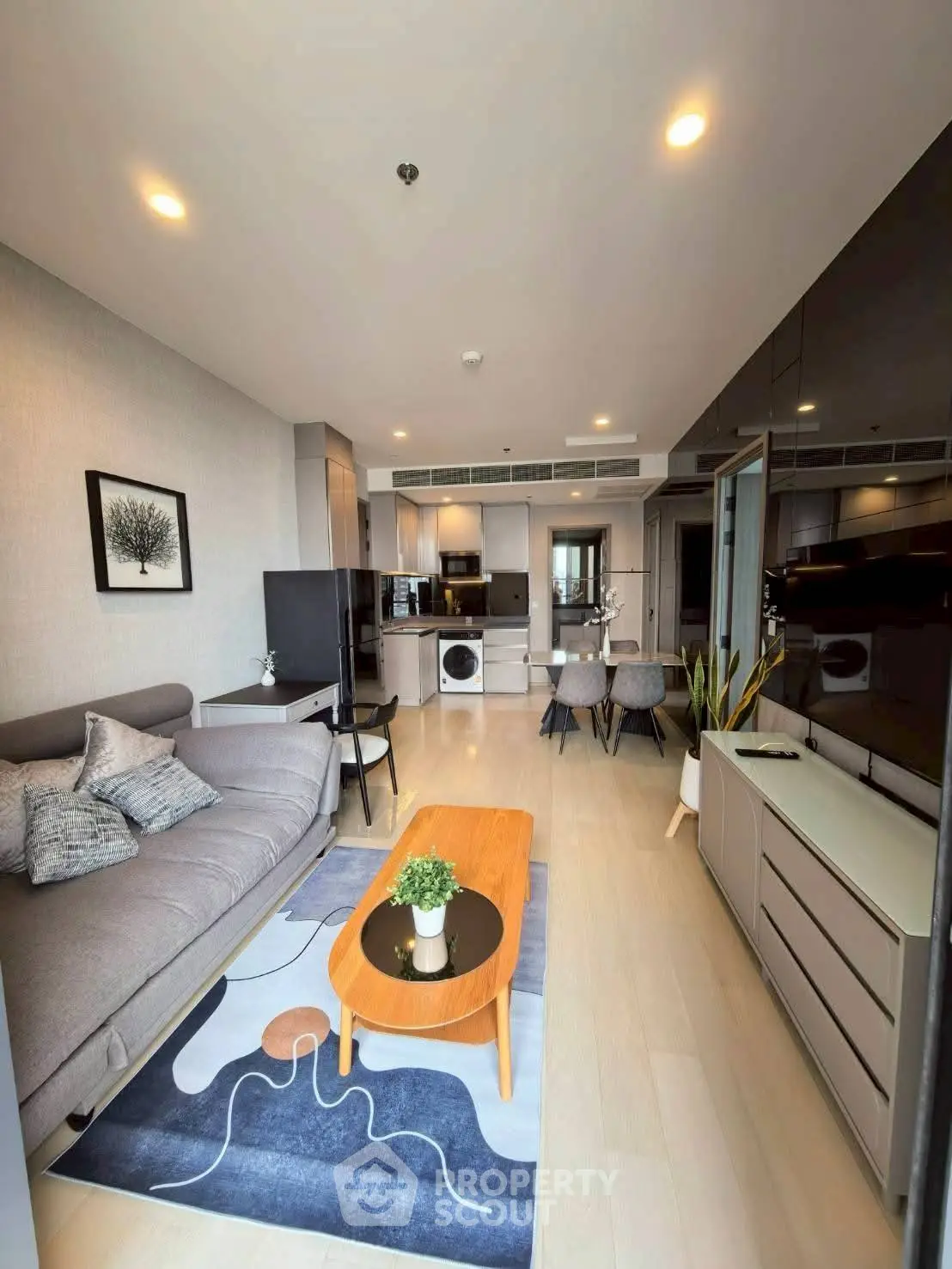 Modern living room with stylish furniture and open kitchen layout in a cozy apartment.
