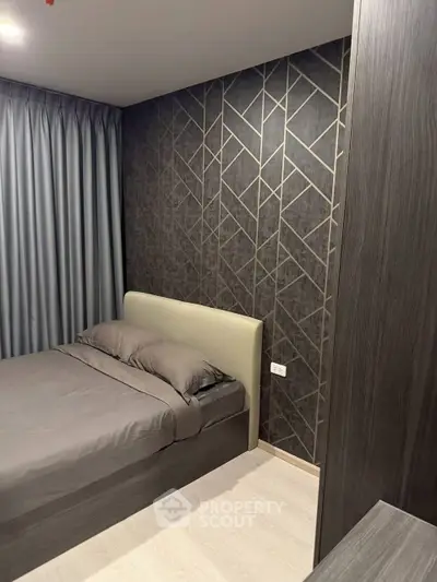 Modern bedroom with stylish geometric accent wall and cozy bedding