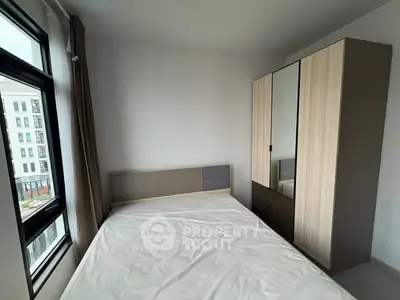 Modern bedroom with large window and sleek wardrobe in a stylish apartment.