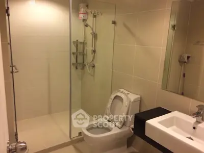 Modern bathroom with glass shower and sleek fixtures in a contemporary apartment.