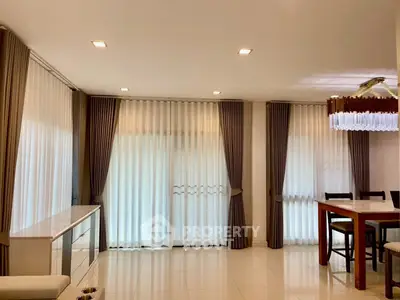 Spacious living room with elegant curtains and modern dining area