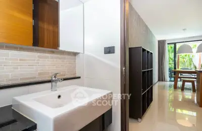 Modern open-plan interior with sleek kitchen and dining area, featuring stylish fixtures and natural light.