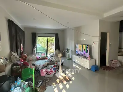 Spacious living room with large window and modern decor, perfect for family gatherings.