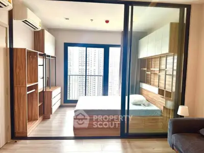Modern bedroom with glass partition and city view, featuring sleek wooden furniture and ample natural light.