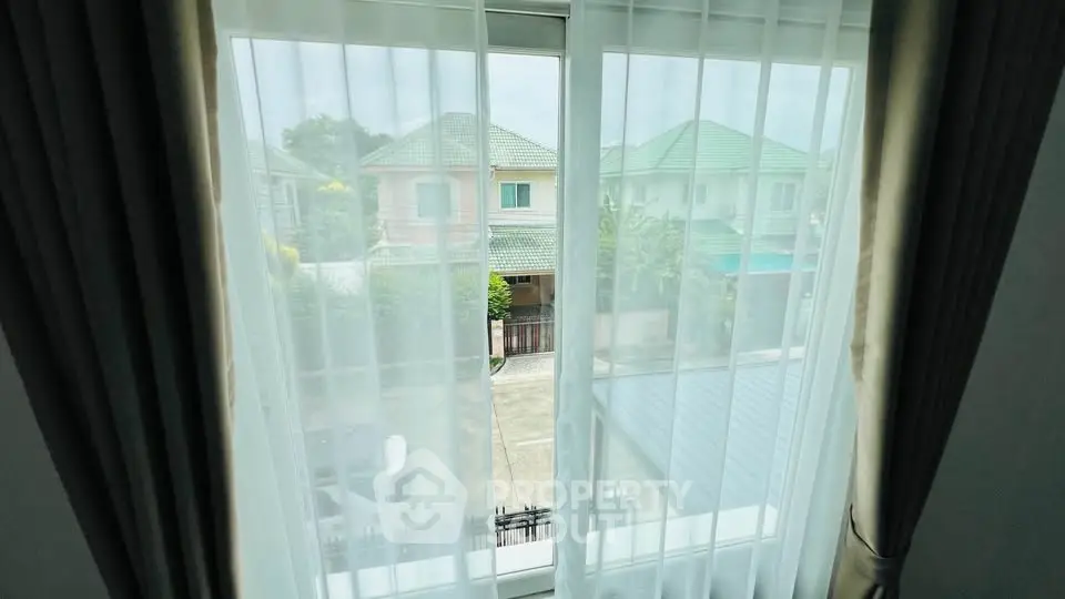 Charming window view showcasing suburban neighborhood with lush greenery and stylish homes.