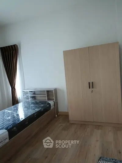 Modern bedroom with wooden floor, bed, and wardrobe in minimalist design.