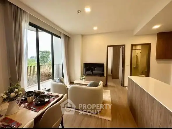 Modern living room with open layout and balcony view, featuring stylish furniture and natural light.