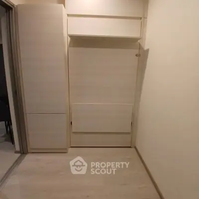 Compact storage space with sleek wooden cabinets in modern apartment.