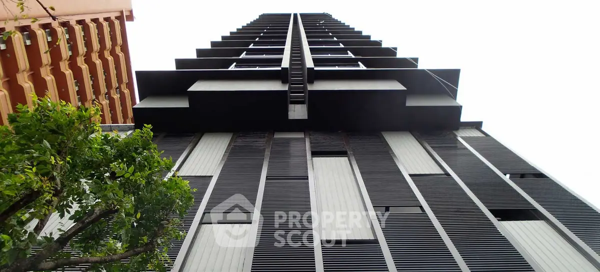 Modern high-rise building with sleek architectural design and vertical lines.