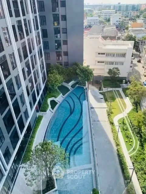 Stunning aerial view of modern apartment complex with luxurious swimming pool and landscaped gardens.
