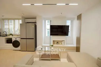 Modern living room with sleek kitchen appliances and stylish decor
