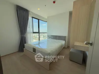 Modern bedroom with large window and city view, featuring sleek wooden furniture and neutral decor.
