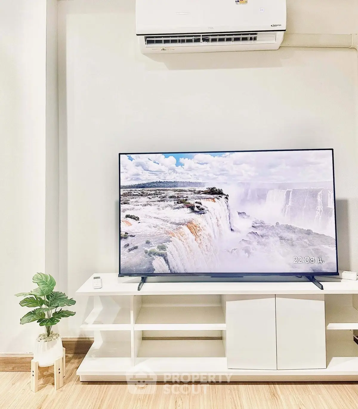 Modern living room with sleek TV setup and air conditioning, perfect for relaxation.
