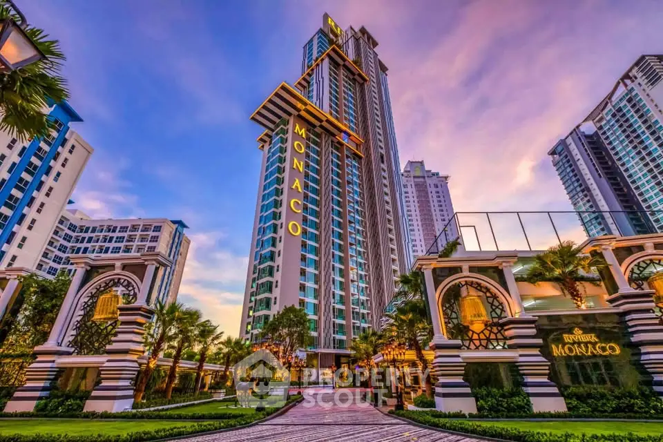 Luxurious high-rise condominium with stunning architecture and lush landscaping at sunset.