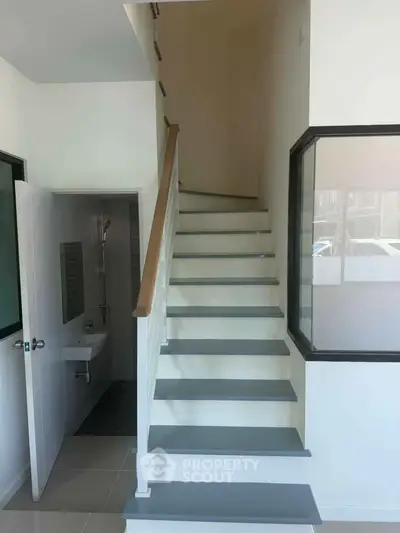 Modern staircase with sleek design and adjacent bathroom in a contemporary home