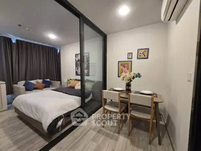 Modern studio apartment with cozy bedroom and dining area, featuring stylish decor and ample natural light.