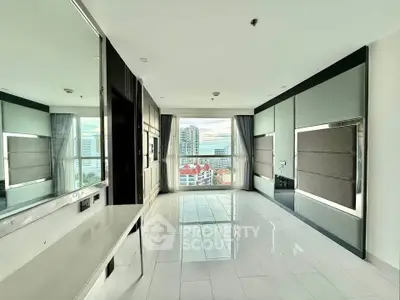 Spacious modern living room with large windows offering stunning city views, sleek design, and ample natural light.