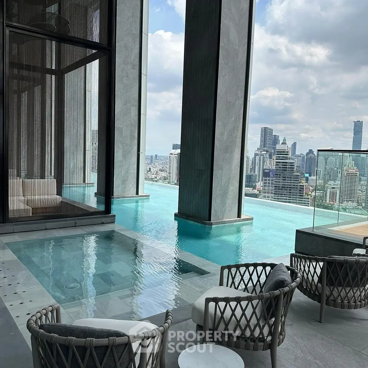 Luxurious rooftop pool with stunning city skyline views and elegant seating area.